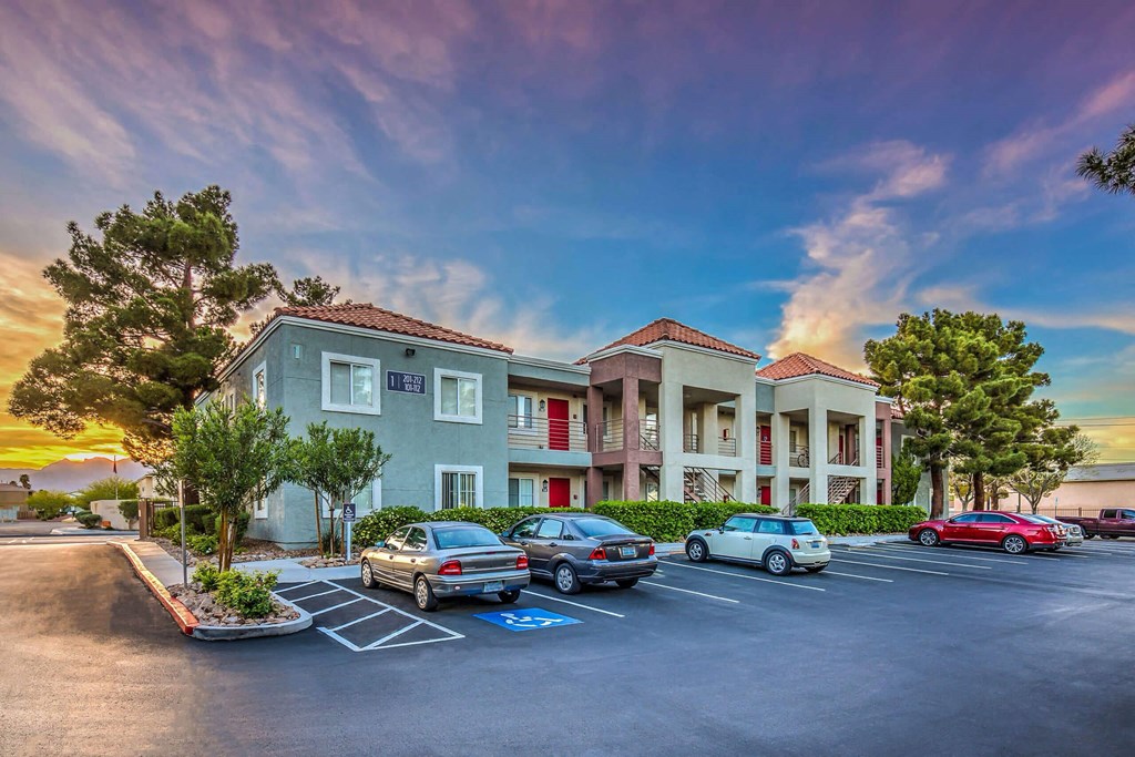 A parking lot in front of a building with cars parked. at Solstice Apartment Homes, Nevada, 89108