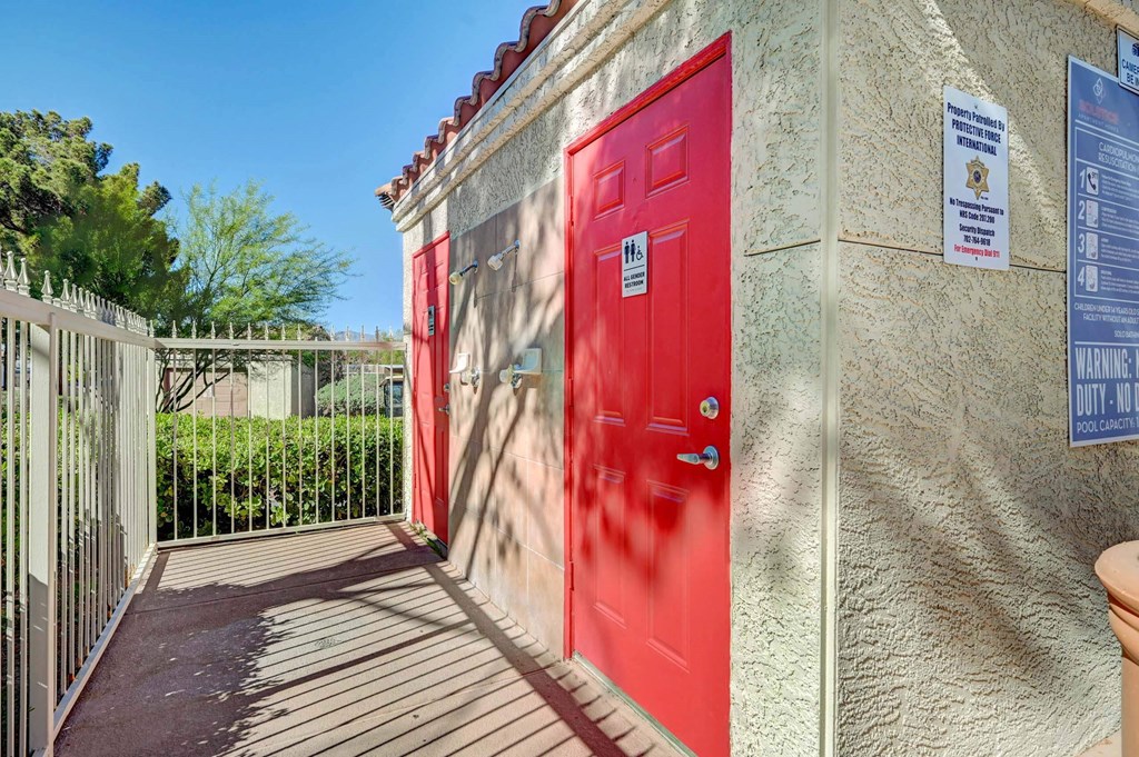 A red door is on the left side of a building with a sign on the right side. at Solstice Apartment Homes, Nevada, 89108