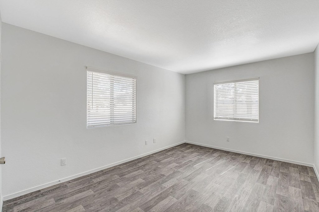 A room with wooden flooring and two windows with blinds. at The 95 Apartments, Las Vegas, 89129