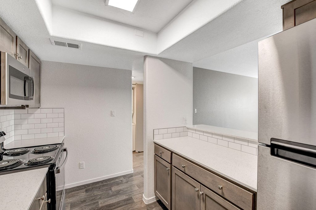 A kitchen with a stove top oven and a refrigerator. at The 95 Apartments, Nevada, 89129