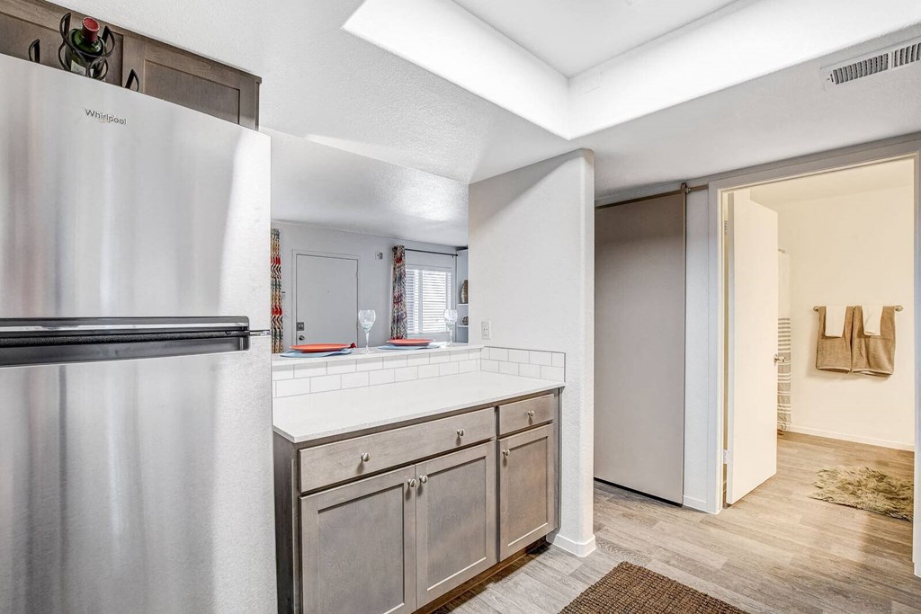 A kitchen with a white refrigerator and wooden cabinets. at The 95 Apartments, Las Vegas, Nevada