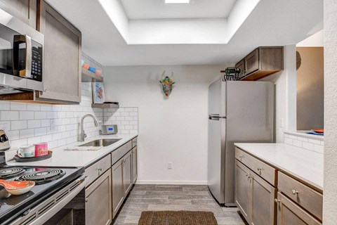 A kitchen with a stove top oven, microwave, and refrigerator.