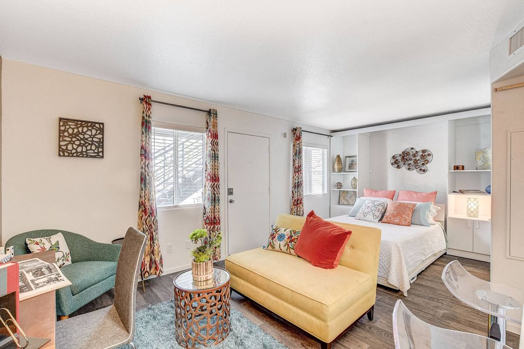 A living room with a yellow sofa and a coffee table. at The 95 Apartments, Nevada