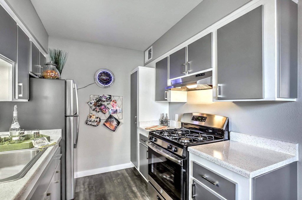A modern kitchen with a stainless steel refrigerator and a stove top oven. at The Neon Apartments, Nevada