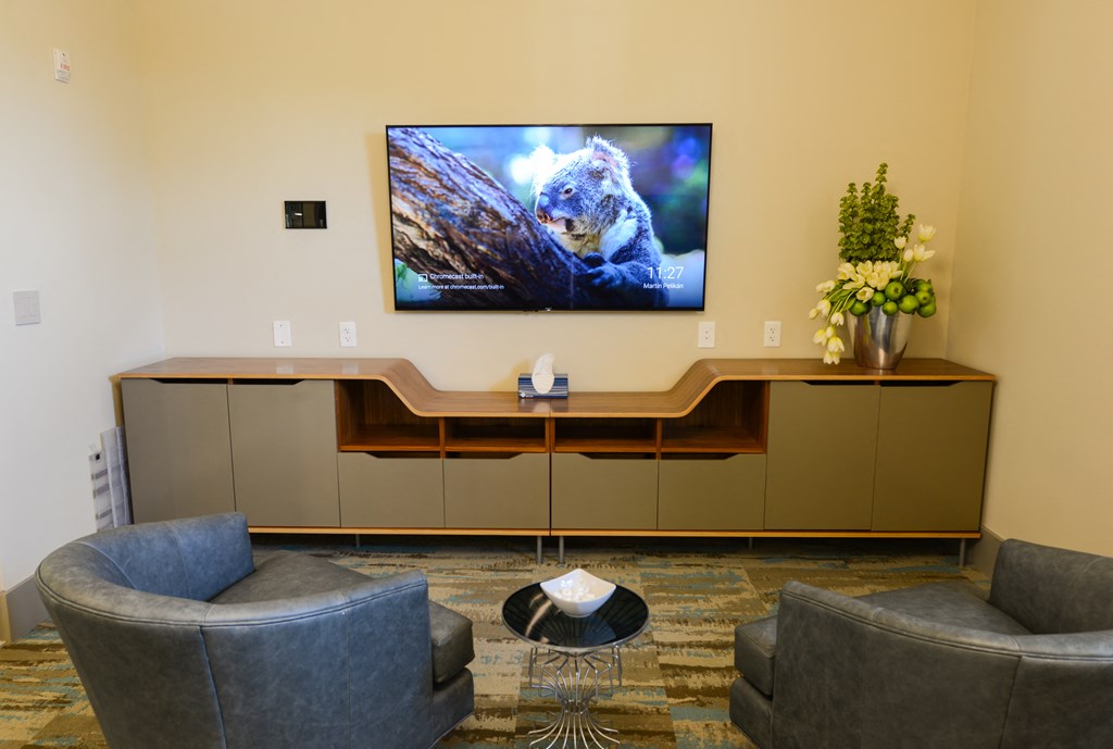a living room with couches and a tv on the wall