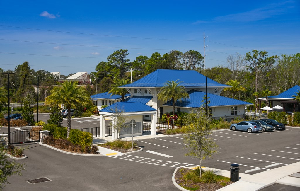 an aerial view of a parking lot and buildings with blue roofs