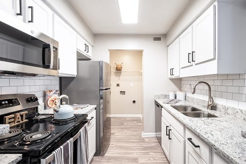 a kitchen with white cabinets and stainless steel appliances