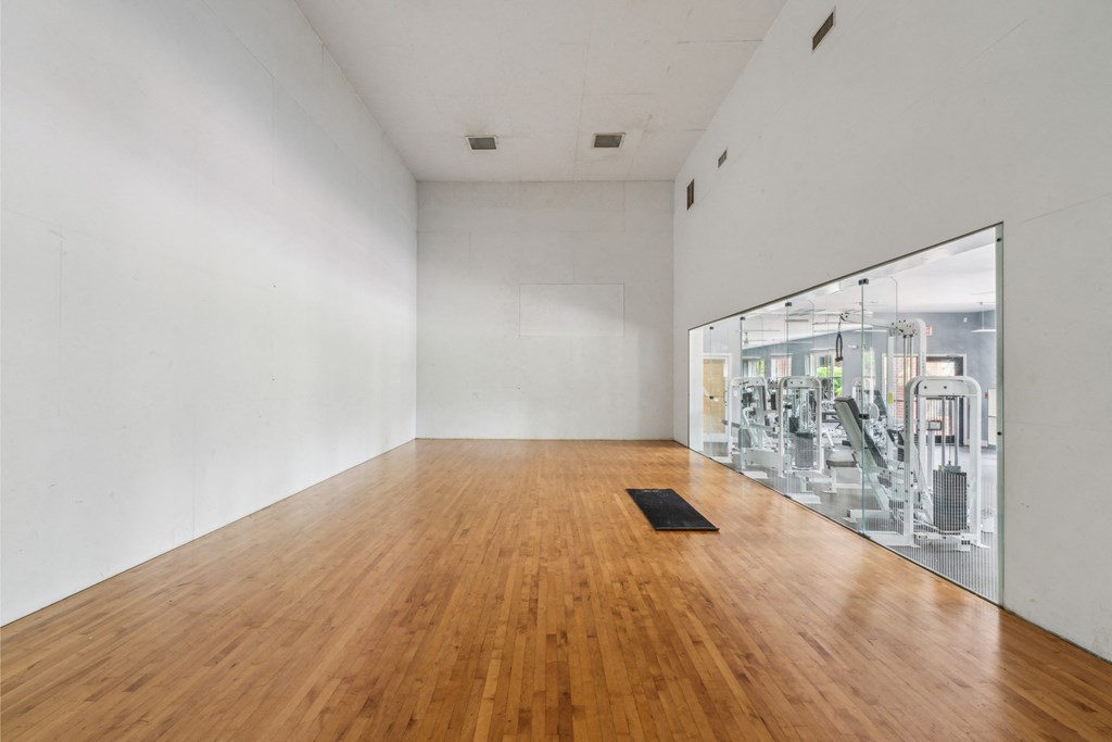 a large white room with a wooden floor and a large glass window
