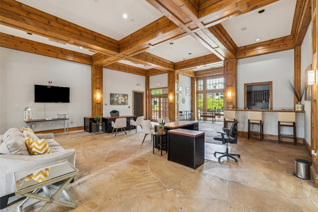 a large living room with exposed wood ceilings and a fireplace