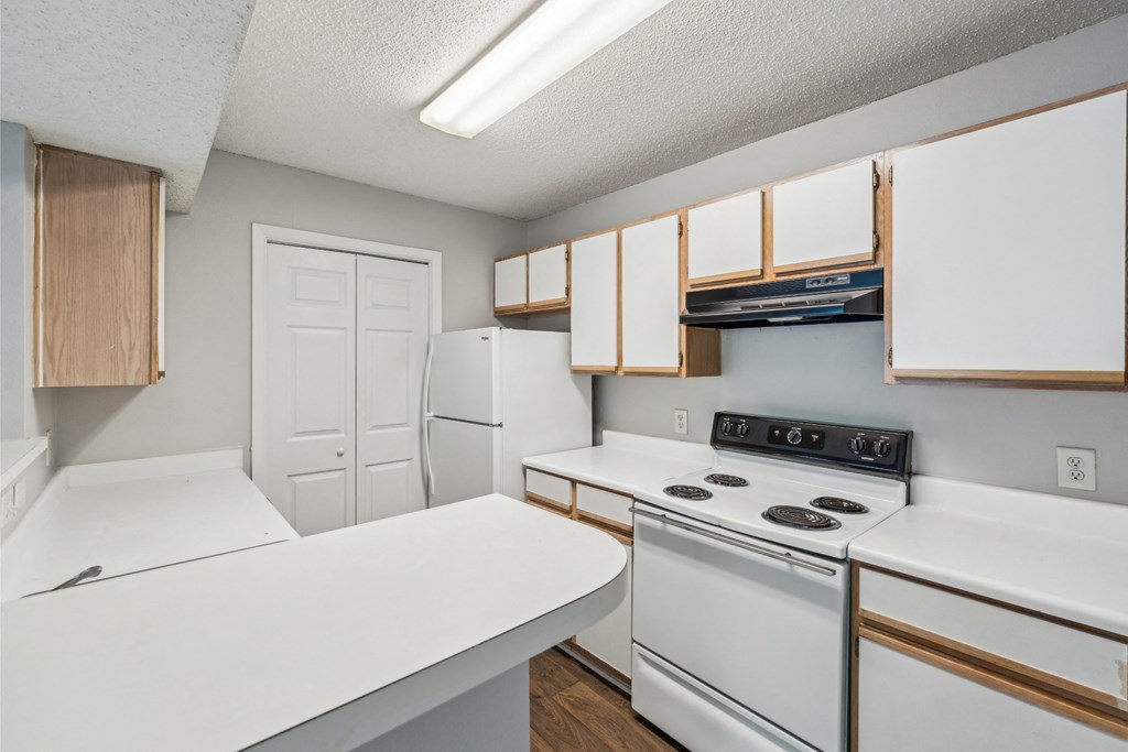a kitchen with white appliances and wooden cabinets and a white refrigerator