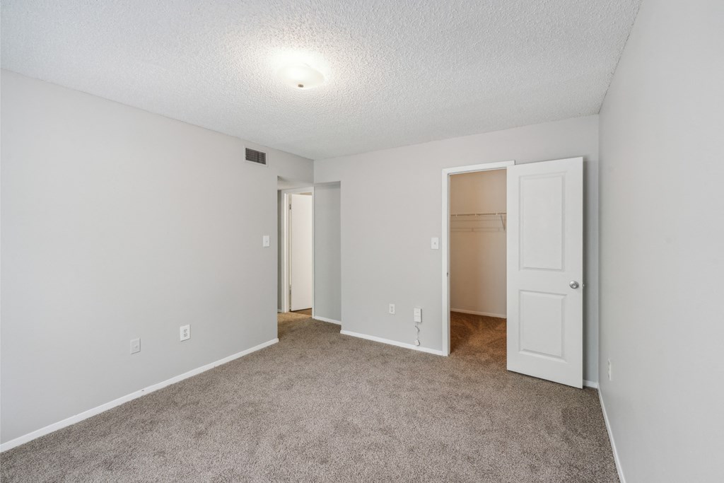 an empty living room with an open door to a closet