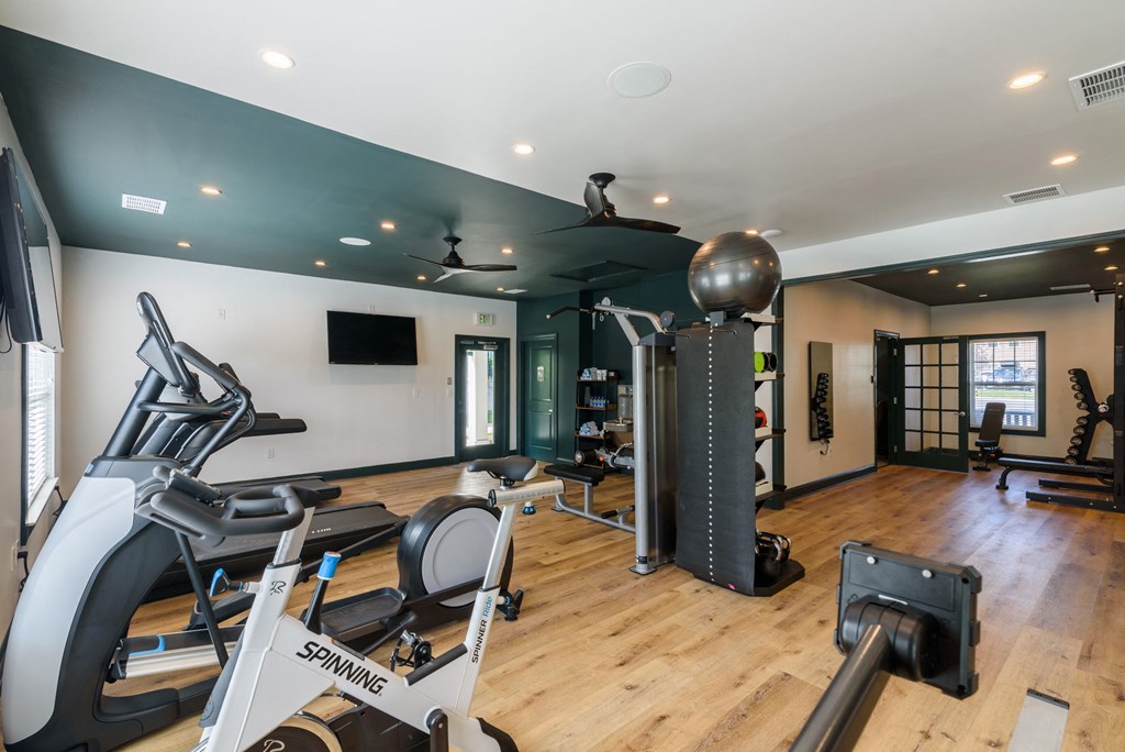 Amenities a gym with exercise equipment and weights on a wooden floor