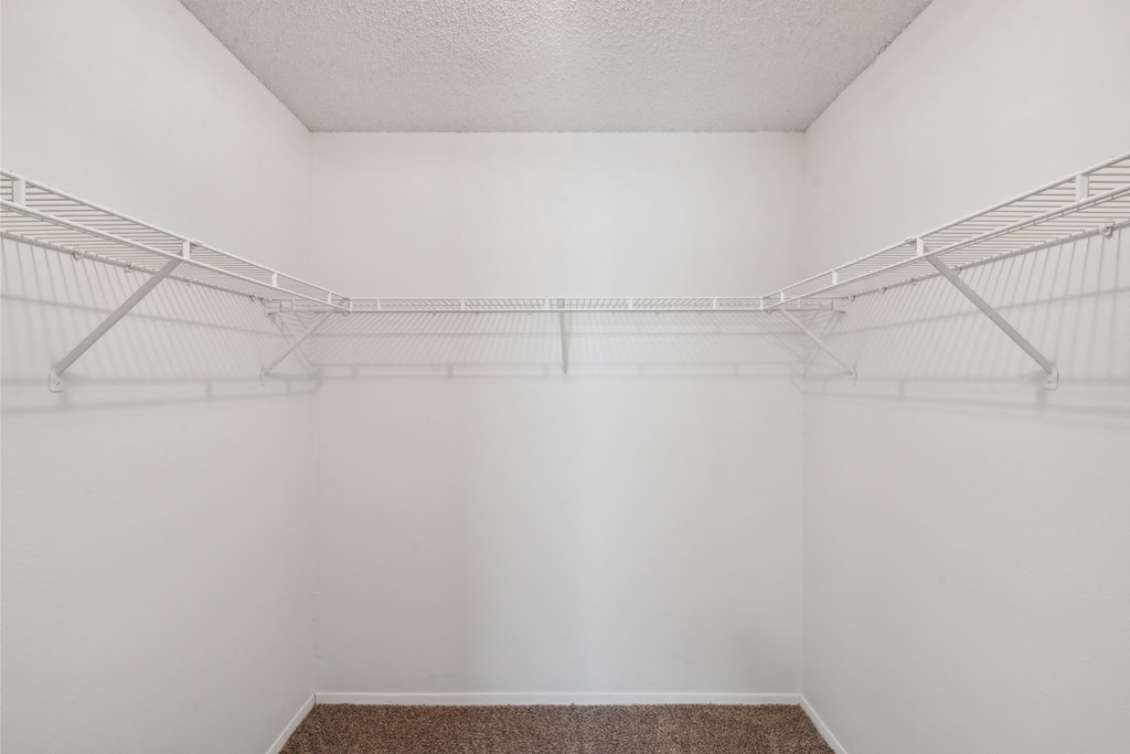 an empty room with white walls and two empty shelves in it