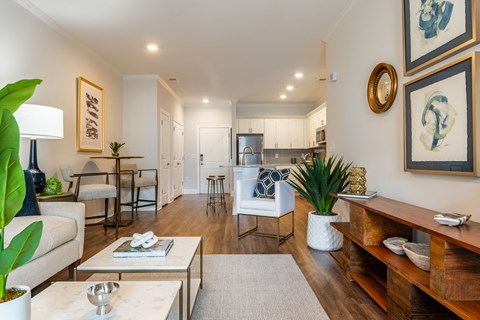 a living room with furniture and a kitchen in the background