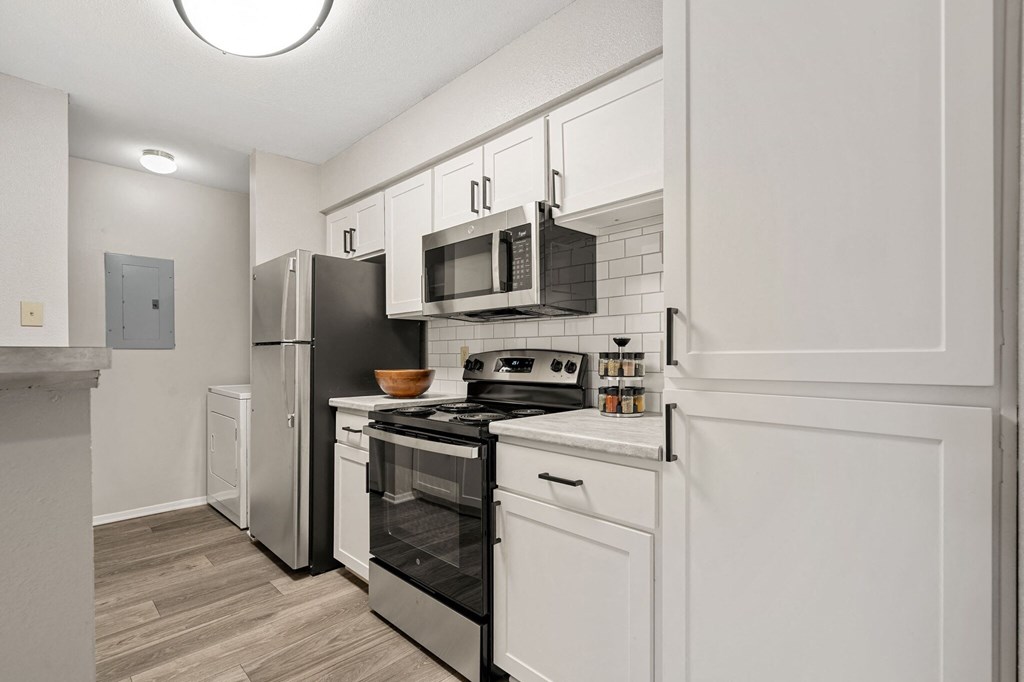 a renovated kitchen with white cabinets and stainless steel appliances