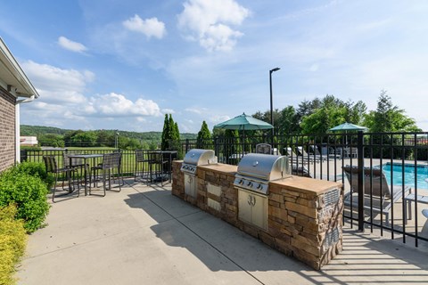 A poolside area with a stone wall and a hot tub.