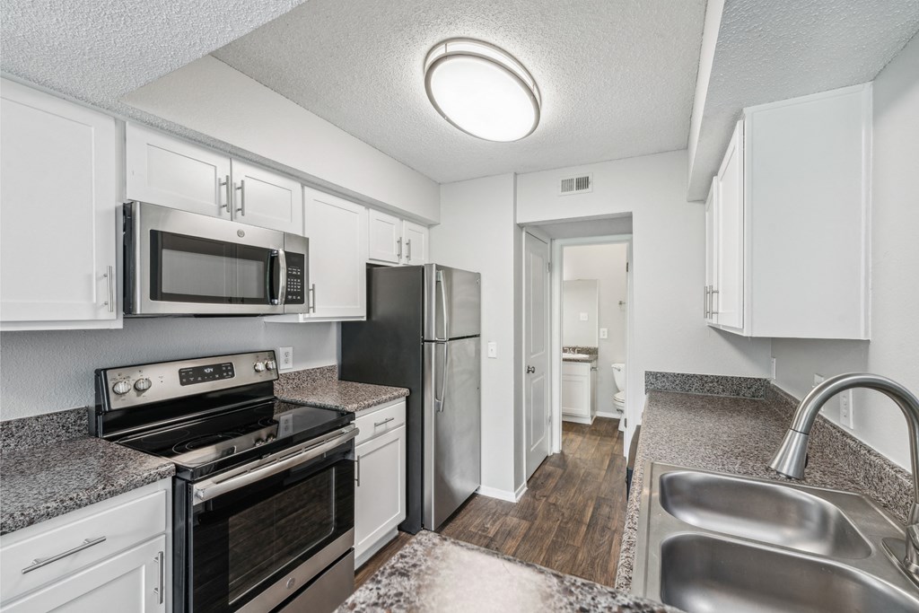 a kitchen with stainless steel appliances and granite counter tops
