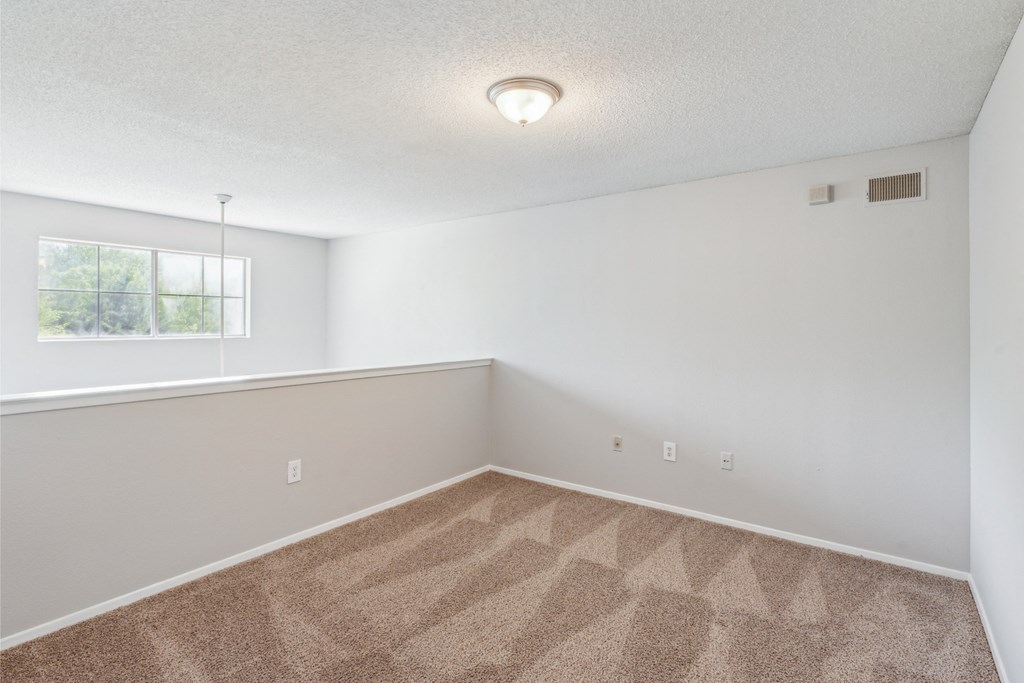 an empty room with carpet and a window