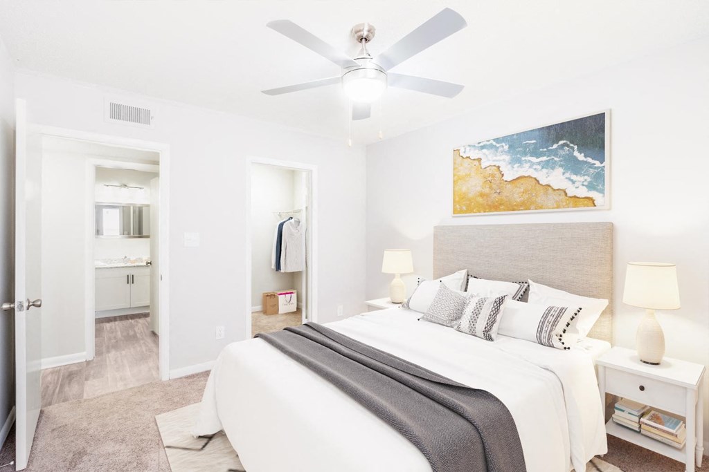 a bedroom with a large bed and a ceiling fan