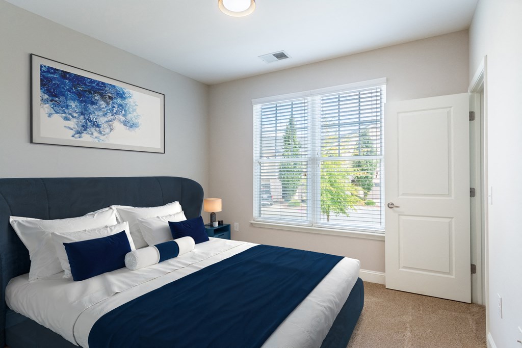 A bedroom with a large window.