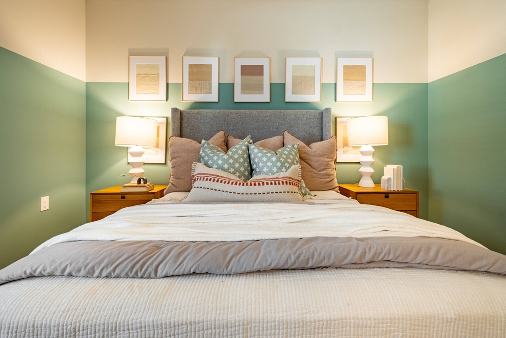 a bedroom with green walls and a bed with pillows