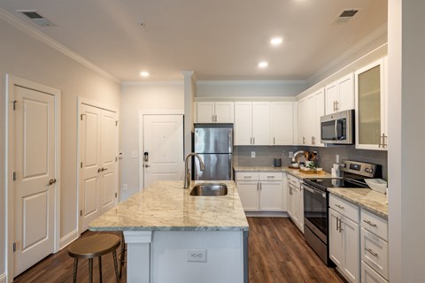 a kitchen with white cabinets and stainless steel appliances