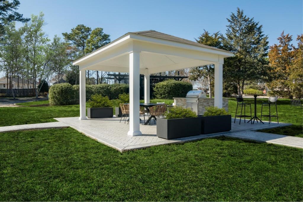 a pavilion with a table and chairs in a yard
