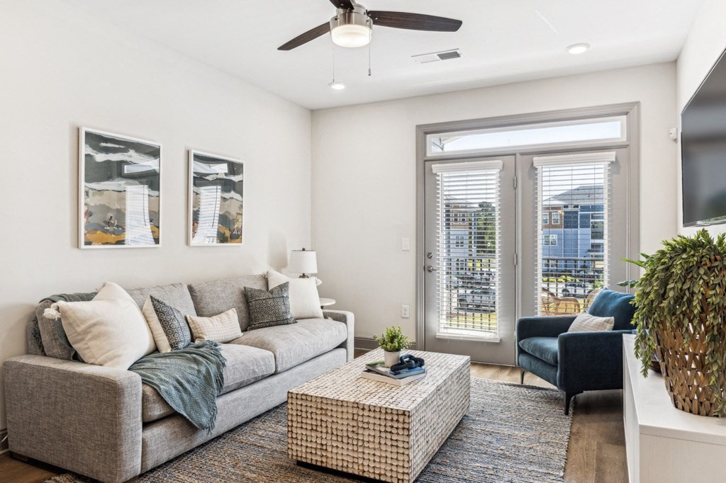 a living room with a couch and a coffee table and a ceiling fan
