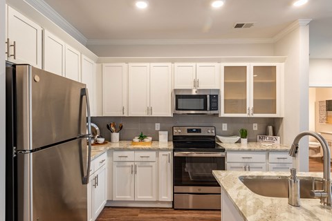 a kitchen with stainless steel appliances and white cabinets