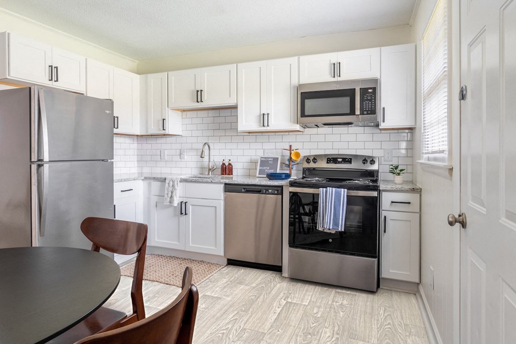 a kitchen with stainless steel appliances and white cabinets