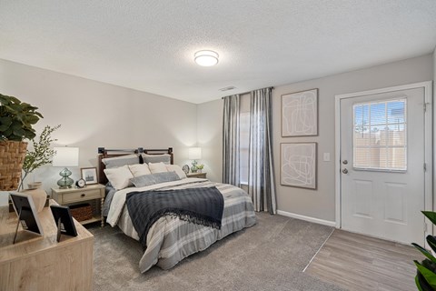 A bedroom with a bed, nightstand, and window.