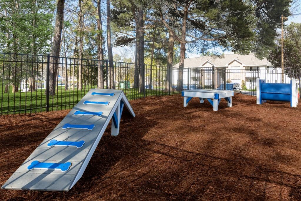 a playground with benches and tables in a fenced in area