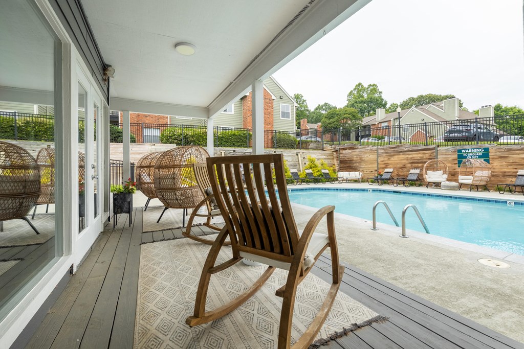 a pool and deck with rocking chairs and a pool