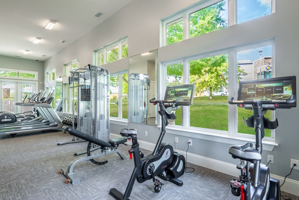 A gym with treadmills, elliptical machines, and stationary bikes.