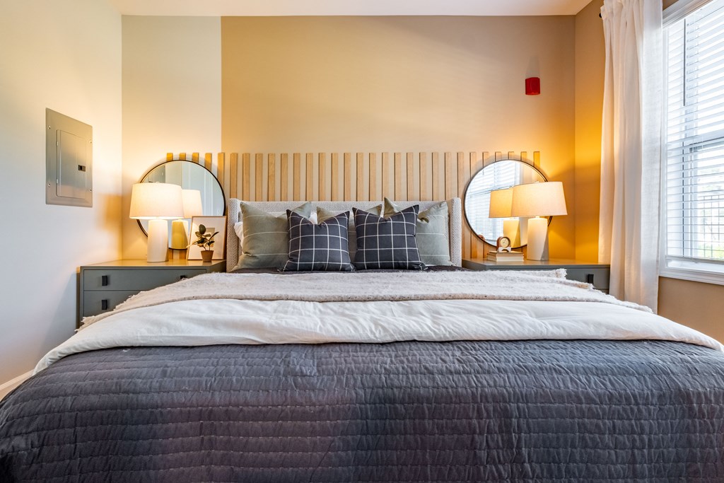 a bedroom with a bed and two mirrors