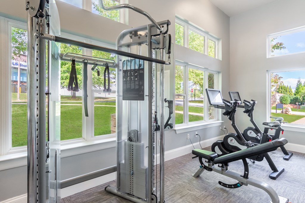 A home gym with a treadmill, weights, and exercise bikes.
