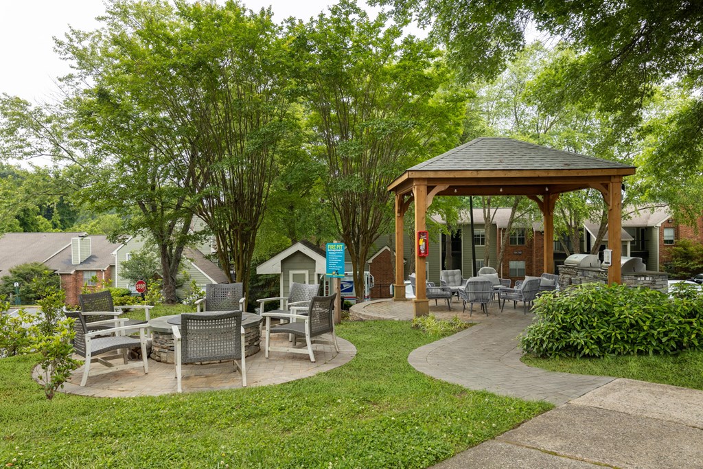 a pavilion with tables and chairs in a garden