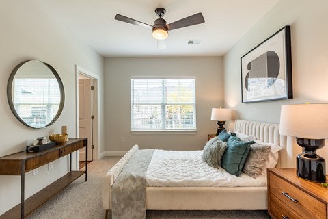 a bedroom with a bed and a ceiling fan