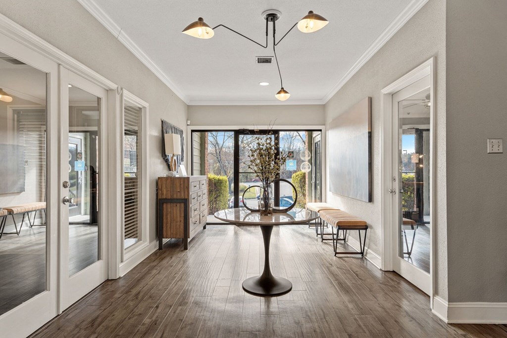 a dining room with a table and chairs in front of a window