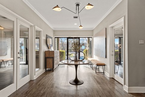 a dining room with a table and chairs in front of a window