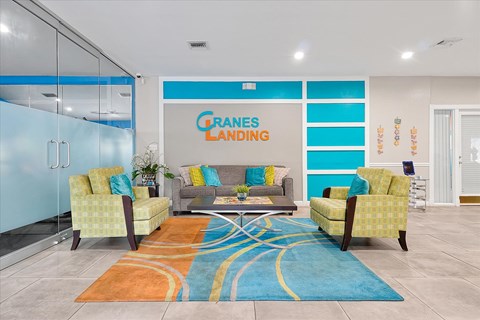 A living room with a couch and chairs in front of a sign that says "Grandes Landing".