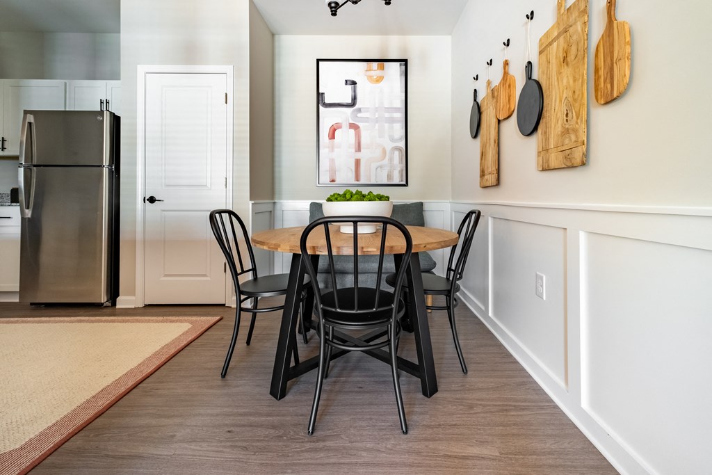 a dining room with a table and chairs and a refrigerator