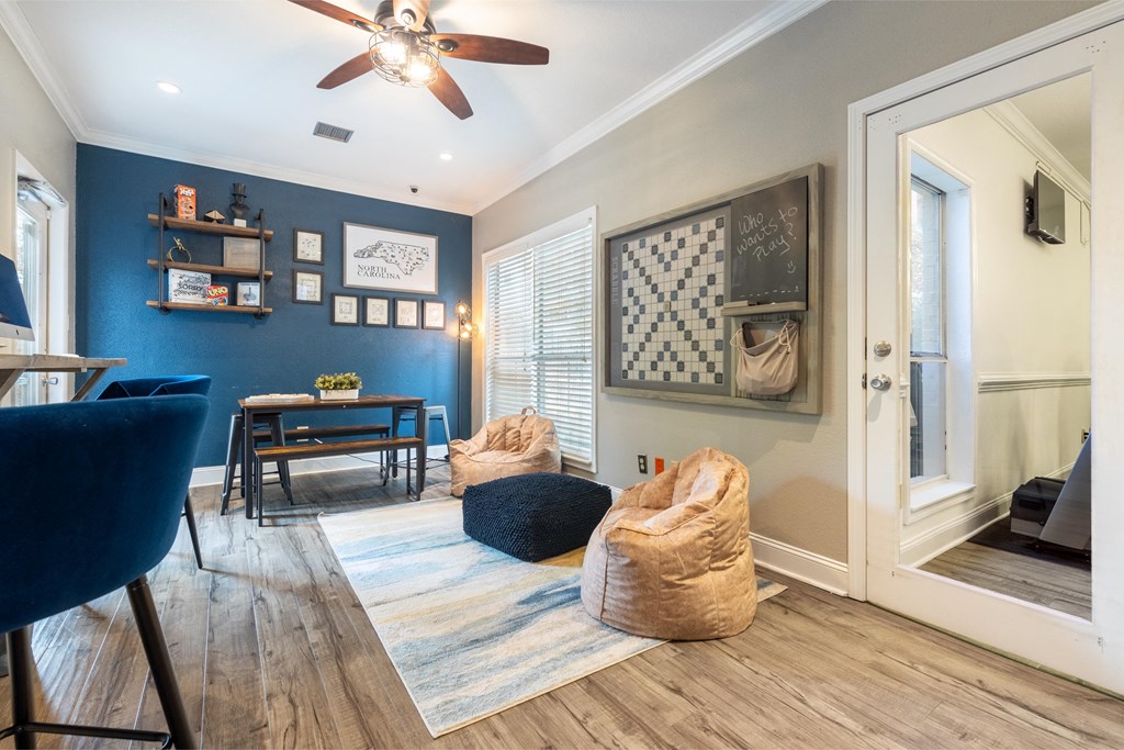 a living room with chairs and a ceiling fan