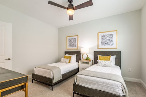 two twin beds in a bedroom with a ceiling fan