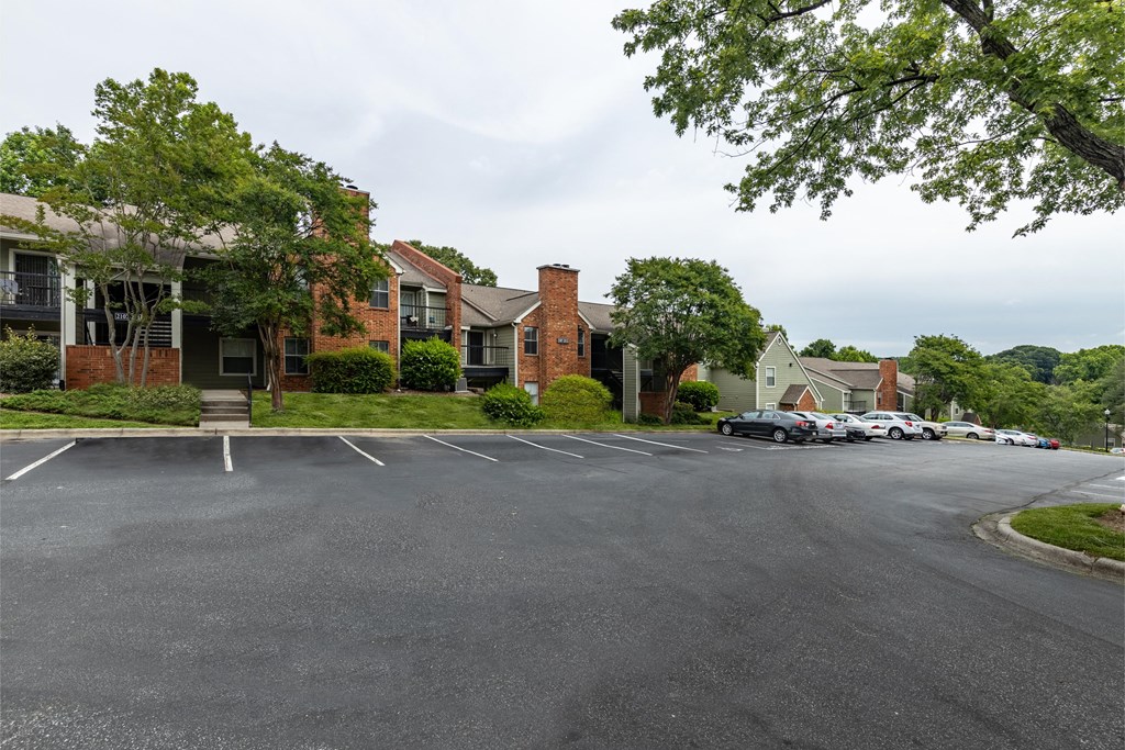 a parking lot in front of a row of apartment buildings