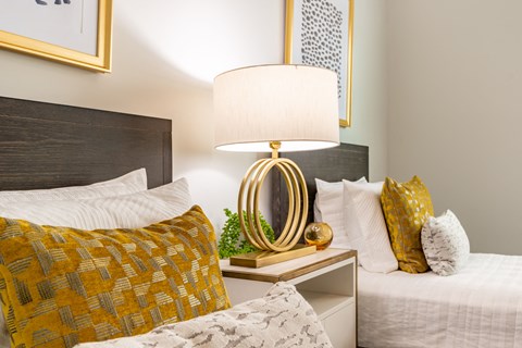 a bedroom with two beds and a nightstand with a lamp