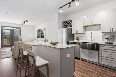 A modern kitchen with a large island and wooden floors.