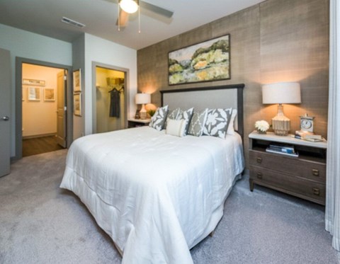 A bedroom with a large bed and a painting on the wall.