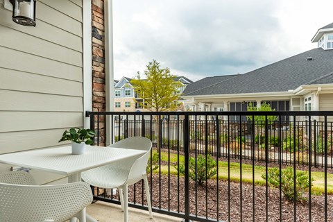 a patio with a table and chairs and a house