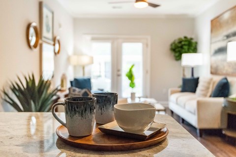 a living room with coffee cups on a table
